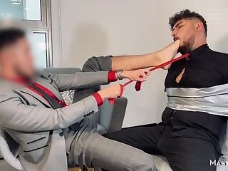 Master with his submissive tied up and putting his foot in the submissive's face